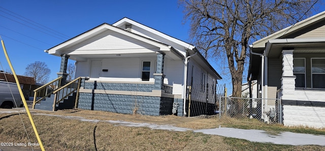 view of front of home featuring covered porch and fence