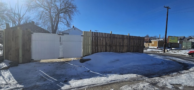 snowy yard with fence and a gate