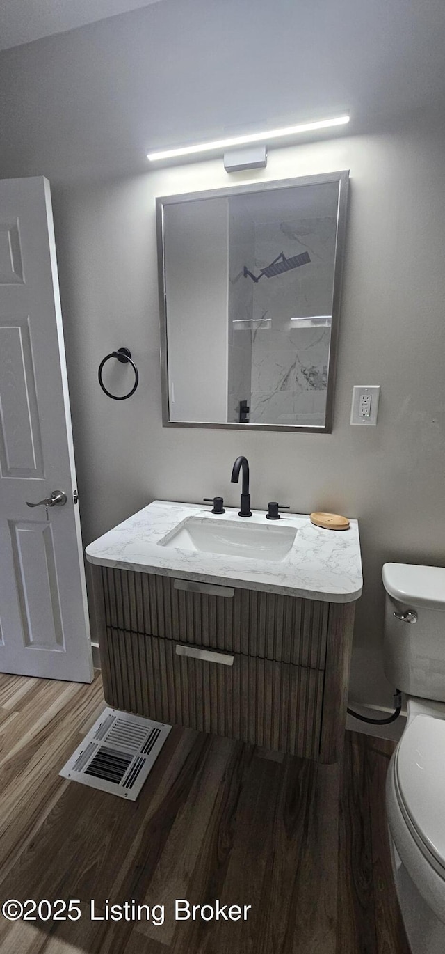 bathroom with vanity, toilet, and wood finished floors