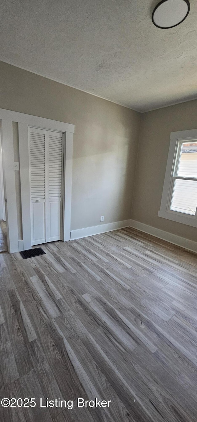 unfurnished bedroom featuring baseboards and wood finished floors