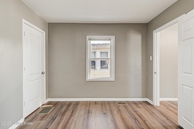 unfurnished room with hardwood / wood-style floors