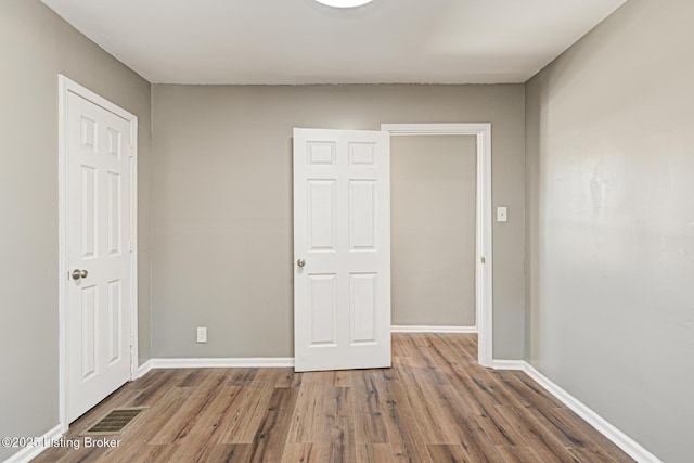 unfurnished bedroom with dark hardwood / wood-style floors