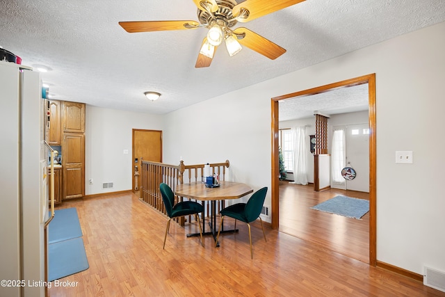 dining room featuring a textured ceiling and light hardwood / wood-style floors