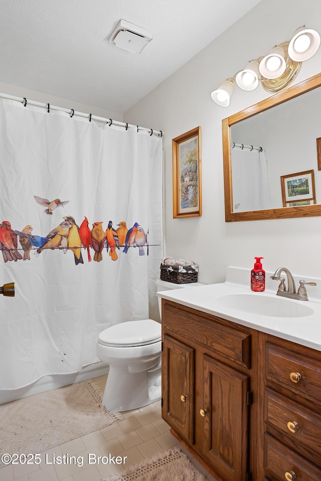 bathroom featuring toilet, vanity, and tile patterned floors