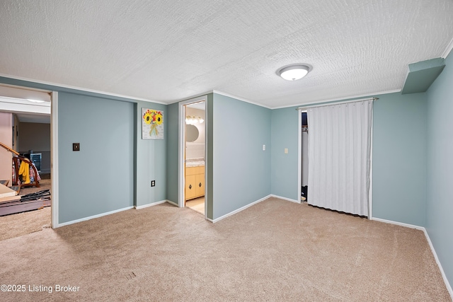 unfurnished bedroom featuring a textured ceiling, connected bathroom, and carpet flooring