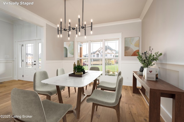 dining room with crown molding and light hardwood / wood-style flooring