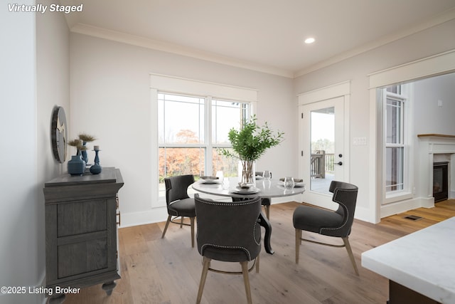 dining space featuring crown molding and light hardwood / wood-style floors