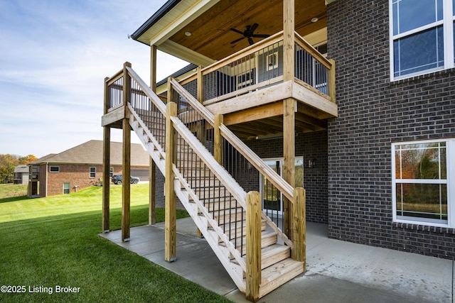 entrance to property featuring a patio, ceiling fan, and a lawn