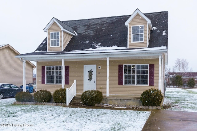 cape cod home featuring covered porch