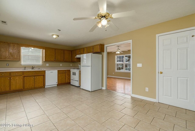 kitchen featuring white appliances, a textured ceiling, sink, ceiling fan, and light tile patterned floors