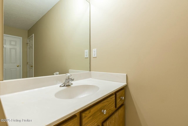 bathroom featuring a textured ceiling and vanity