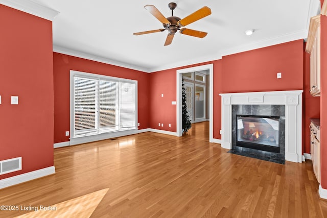 unfurnished living room with ceiling fan, wood-type flooring, crown molding, and a fireplace