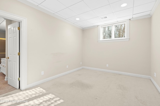 empty room with light colored carpet and a drop ceiling