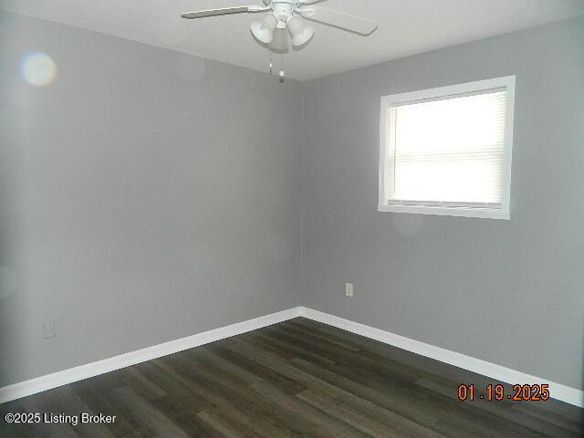 spare room with dark wood-type flooring and ceiling fan