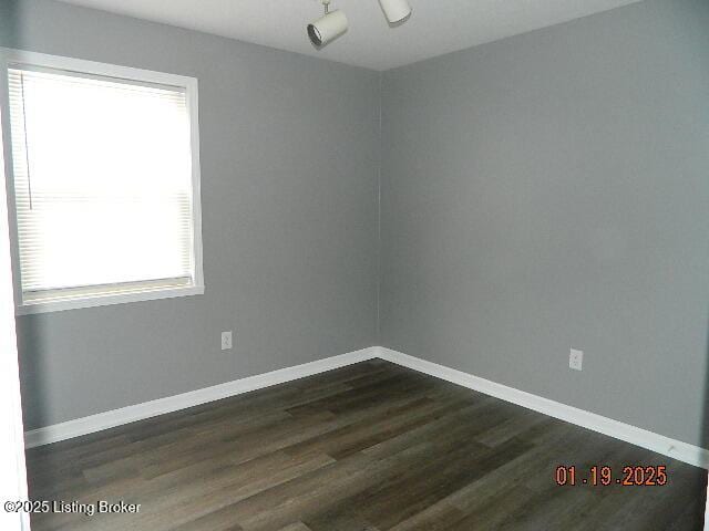 unfurnished room with dark hardwood / wood-style flooring