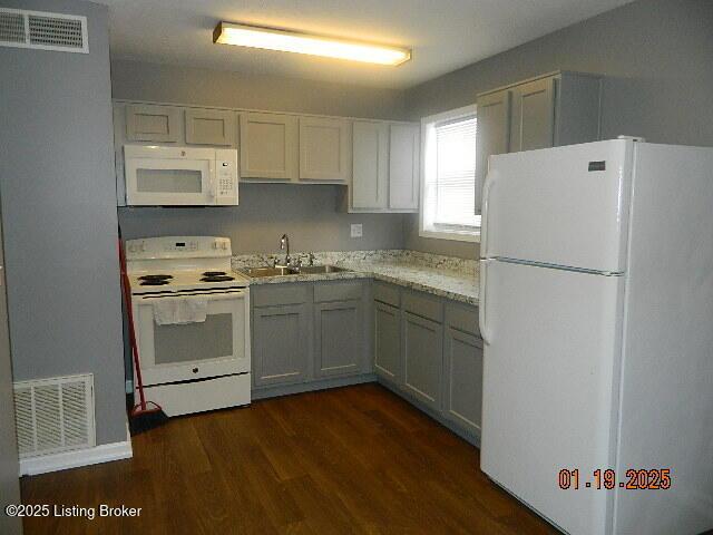 kitchen with dark hardwood / wood-style flooring, sink, white appliances, and white cabinets