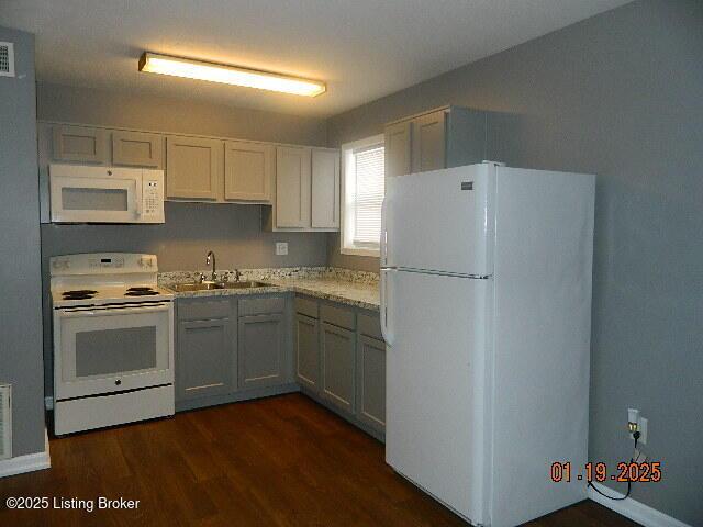 kitchen featuring white cabinetry, sink, white appliances, and dark wood-type flooring