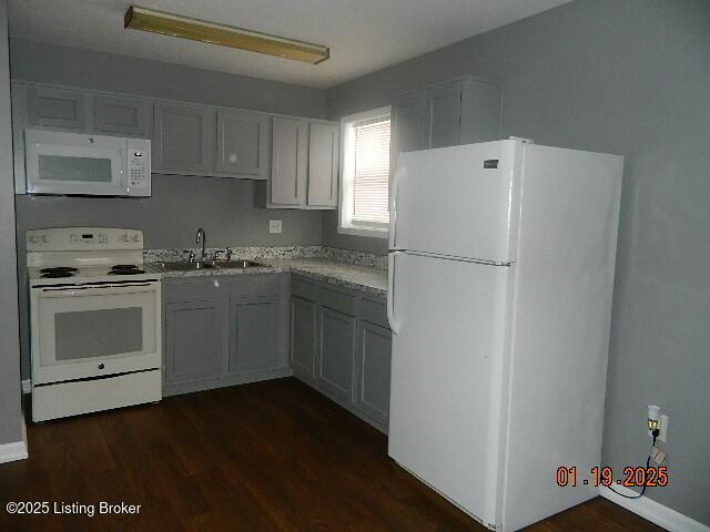 kitchen featuring sink, white appliances, dark wood-type flooring, and gray cabinets