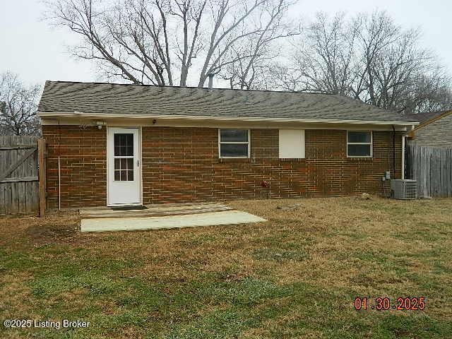 back of house with central AC and a lawn