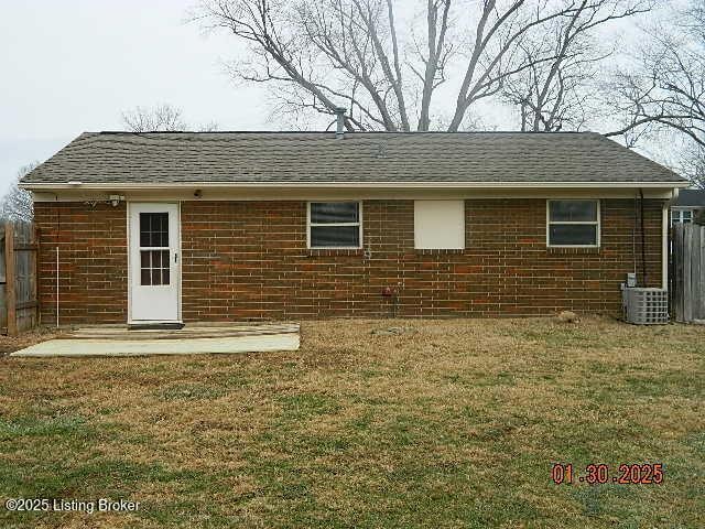 rear view of house with a yard and central AC unit