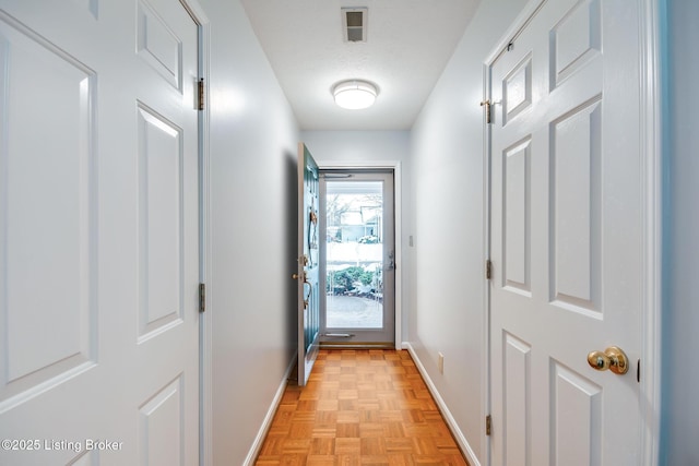 doorway to outside with light parquet flooring and a textured ceiling