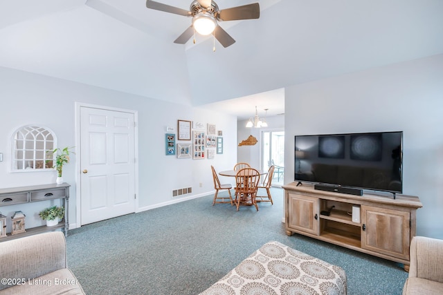 living room featuring lofted ceiling, ceiling fan with notable chandelier, and carpet flooring