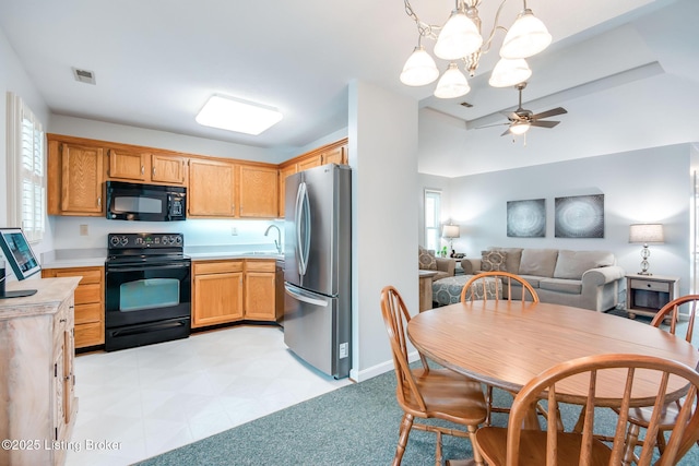 kitchen featuring hanging light fixtures, black appliances, sink, and ceiling fan