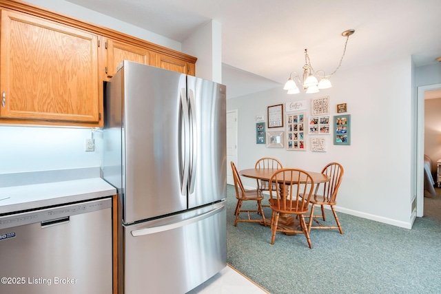 kitchen featuring a notable chandelier, appliances with stainless steel finishes, pendant lighting, and carpet