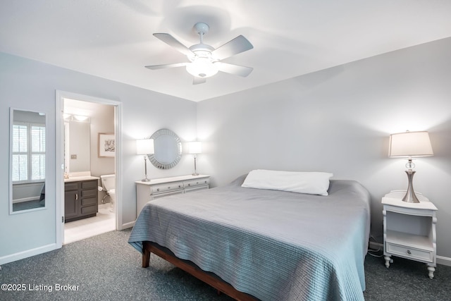 bedroom featuring ceiling fan, ensuite bath, and dark colored carpet