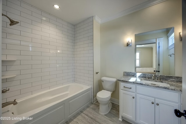 bathroom featuring bathtub / shower combination, toilet, wood finished floors, vanity, and baseboards