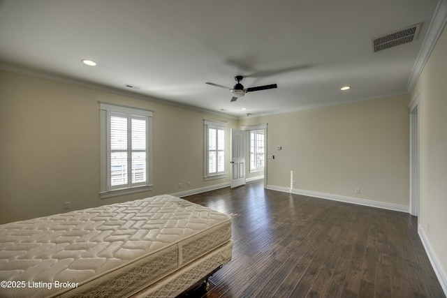 unfurnished bedroom featuring dark wood-style floors, baseboards, visible vents, and crown molding