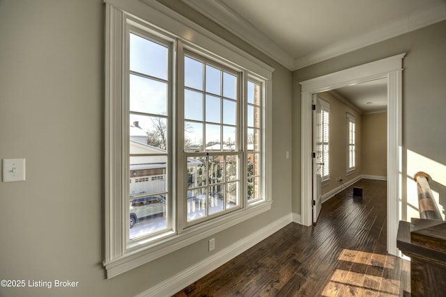 entryway with ornamental molding, dark wood-type flooring, and baseboards