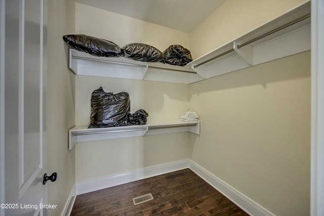 walk in closet with dark wood-style flooring and visible vents