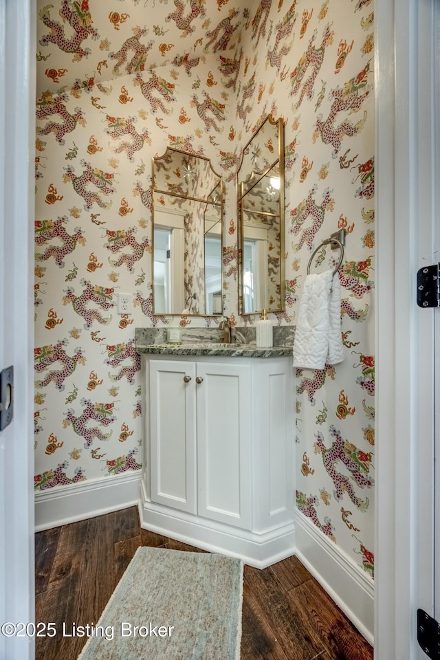 bathroom with wallpapered walls, baseboards, and wood finished floors