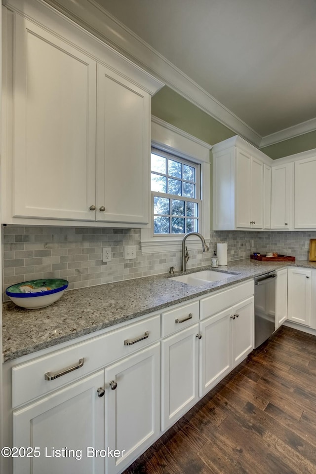 kitchen featuring dishwasher, a sink, white cabinetry, and crown molding