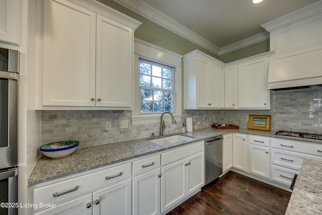 kitchen featuring crown molding, white cabinetry, stainless steel appliances, and a sink