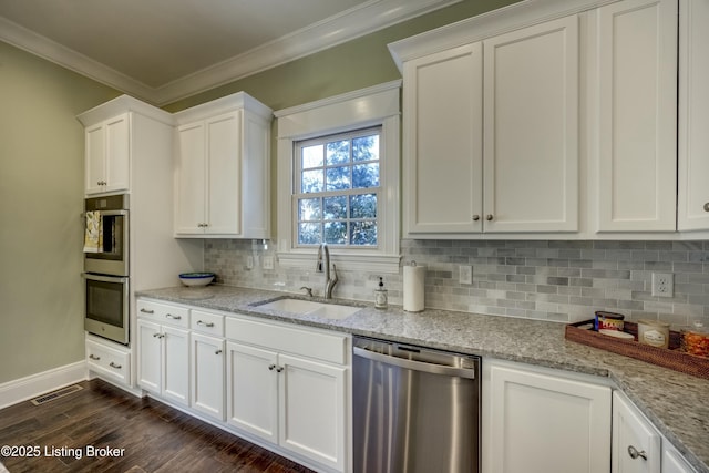 kitchen featuring crown molding, appliances with stainless steel finishes, dark wood-type flooring, white cabinets, and a sink