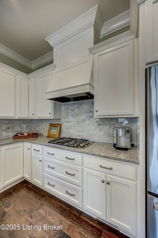 kitchen featuring white cabinetry, ornamental molding, stainless steel appliances, and decorative backsplash