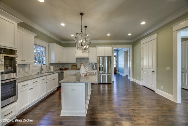 kitchen with crown molding, white cabinetry, stainless steel appliances, and a sink