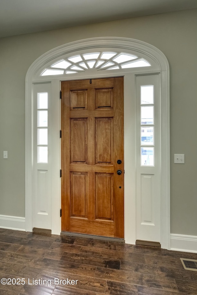 foyer featuring dark wood-type flooring, visible vents, and a healthy amount of sunlight