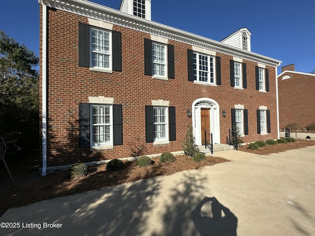 colonial home featuring brick siding