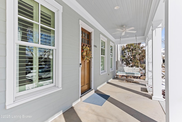 view of exterior entry with ceiling fan and a porch