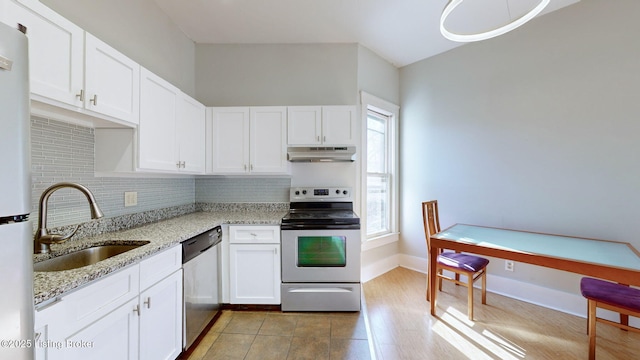 kitchen featuring sink, a healthy amount of sunlight, stainless steel appliances, white cabinets, and light stone counters