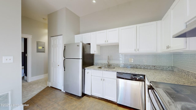 kitchen with white cabinets, appliances with stainless steel finishes, tasteful backsplash, sink, and light stone counters