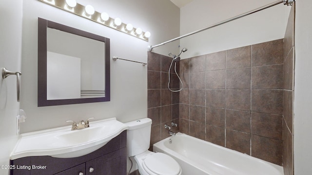 full bathroom featuring toilet, vanity, and tiled shower / bath