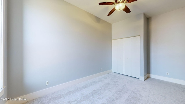 unfurnished bedroom featuring ceiling fan, light colored carpet, and a closet