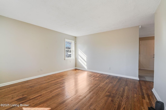 spare room with dark hardwood / wood-style floors and a textured ceiling