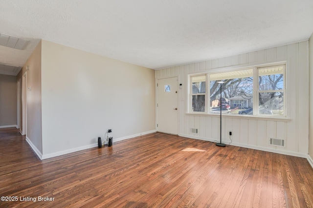 unfurnished room featuring a textured ceiling and dark hardwood / wood-style flooring