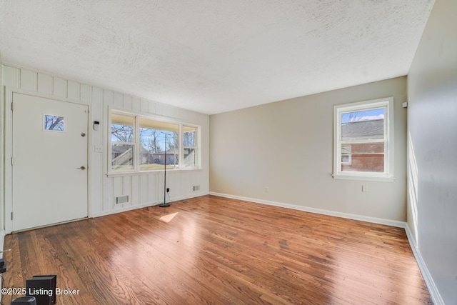 foyer featuring wood-type flooring and a textured ceiling