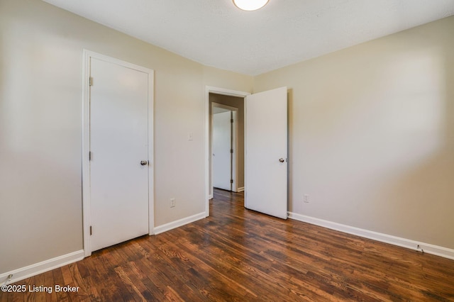 unfurnished bedroom with dark hardwood / wood-style flooring